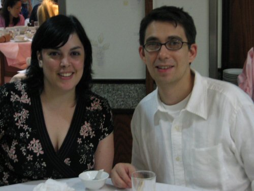 two people are smiling for the camera at a table