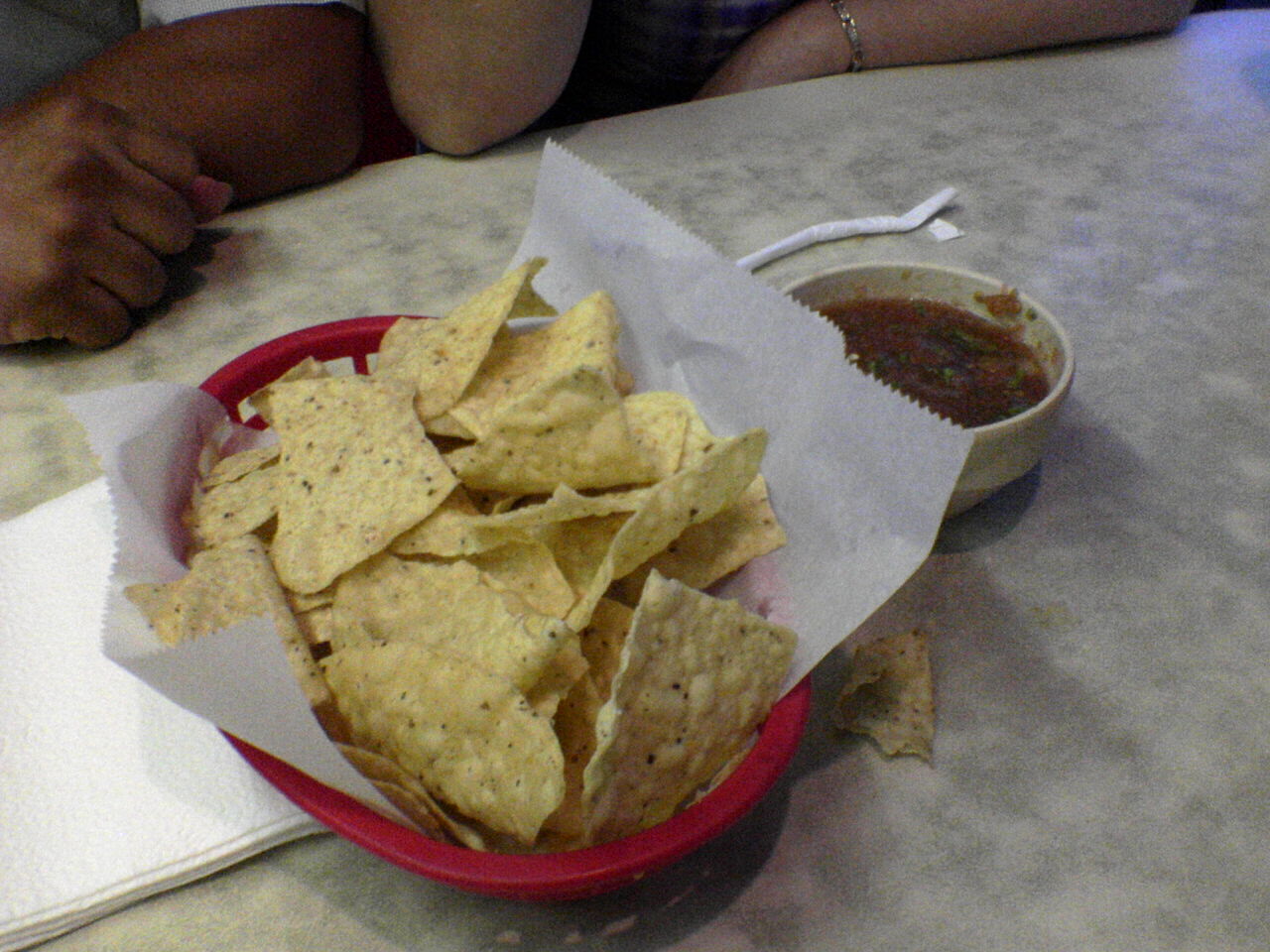 a basket of tortilla chips and salsa is displayed