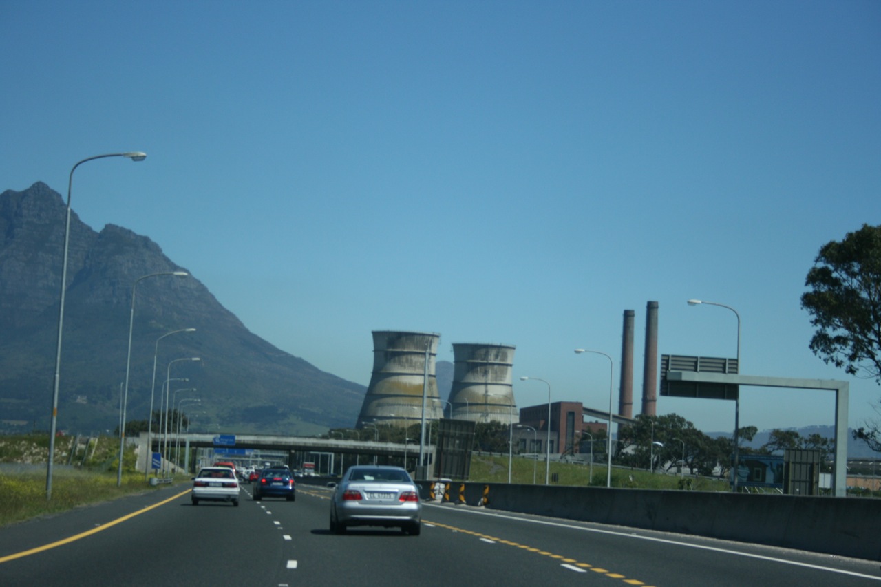 cars drive down a road in front of nuclear power plants