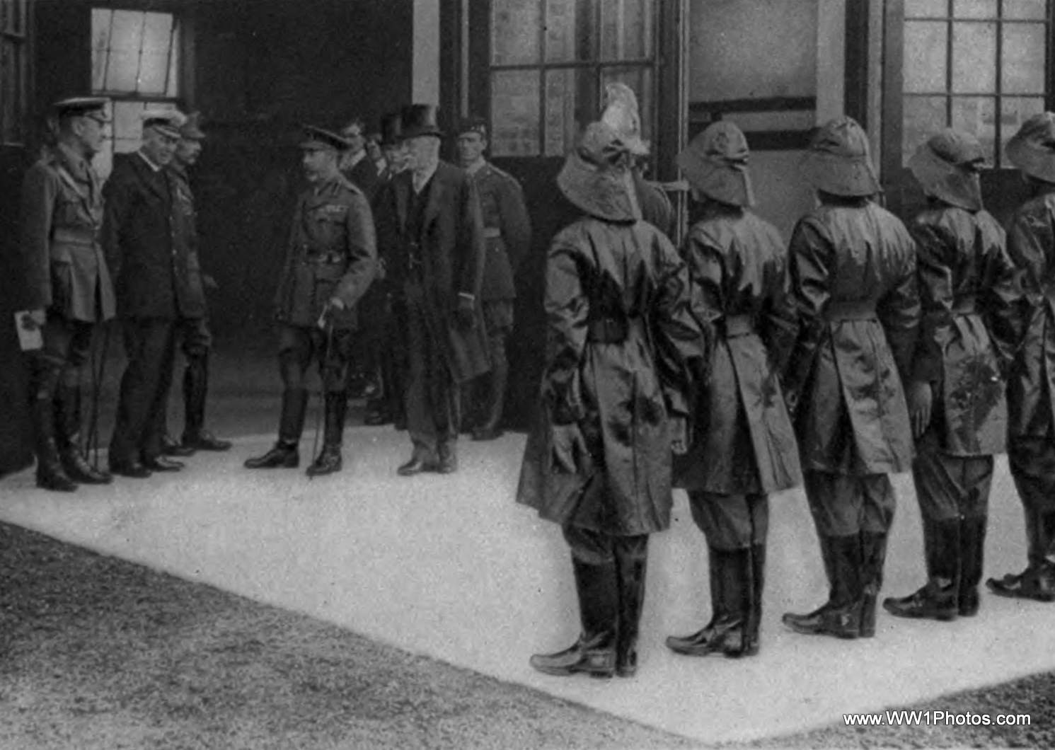 several men in trenchcoats are lined up outside