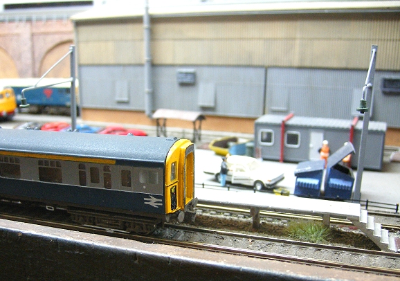 toy trains on track in miniature setting of train station