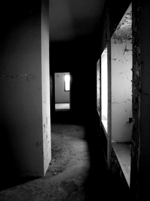 a dark hallway with door to another room