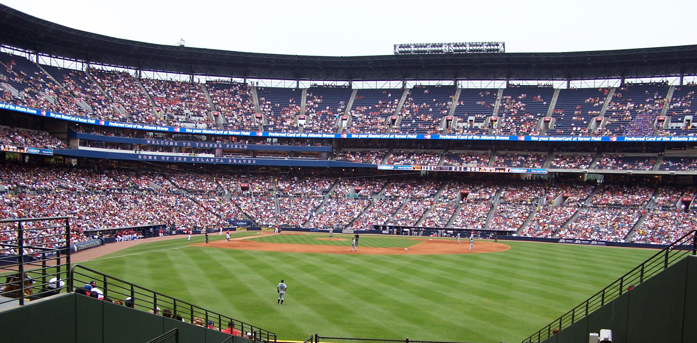 a baseball stadium filled with people watching a game