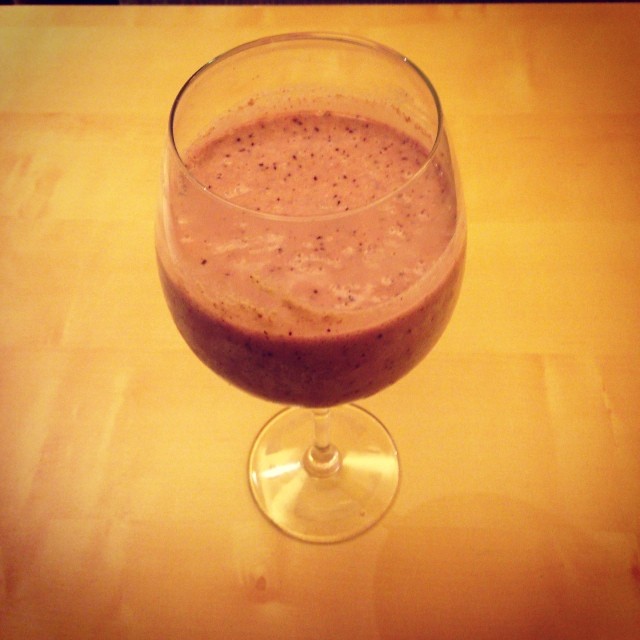 a smoothie in a glass with a brown substance