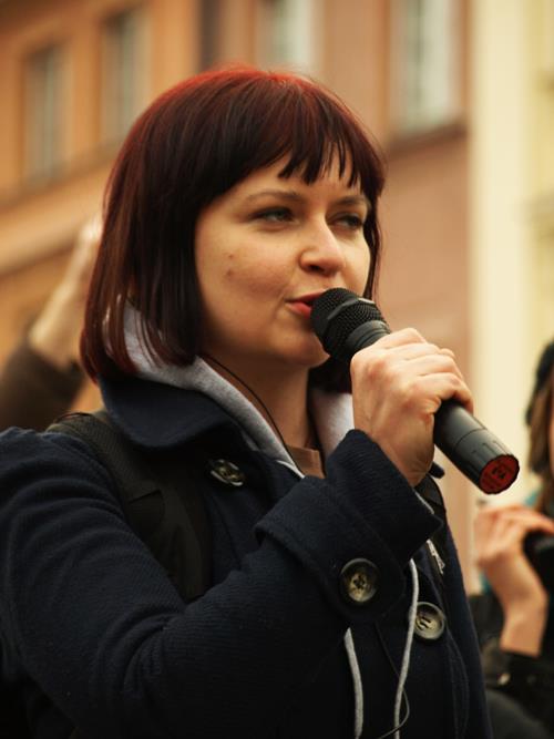 a woman holding a microphone talking to someone