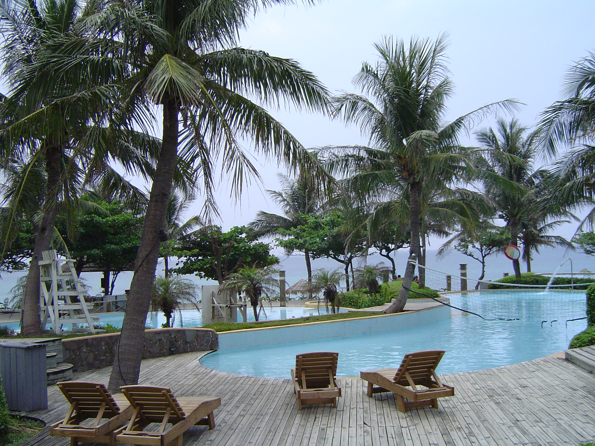 wooden chairs sitting next to an empty swimming pool