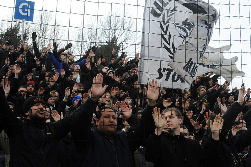 people holding signs behind a fence with hands