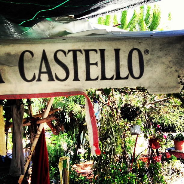 a sign hanging over a garden that says casteello