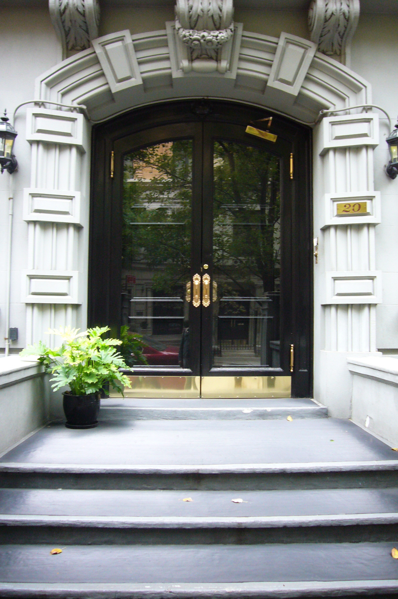 the door of a large building with planters on the steps