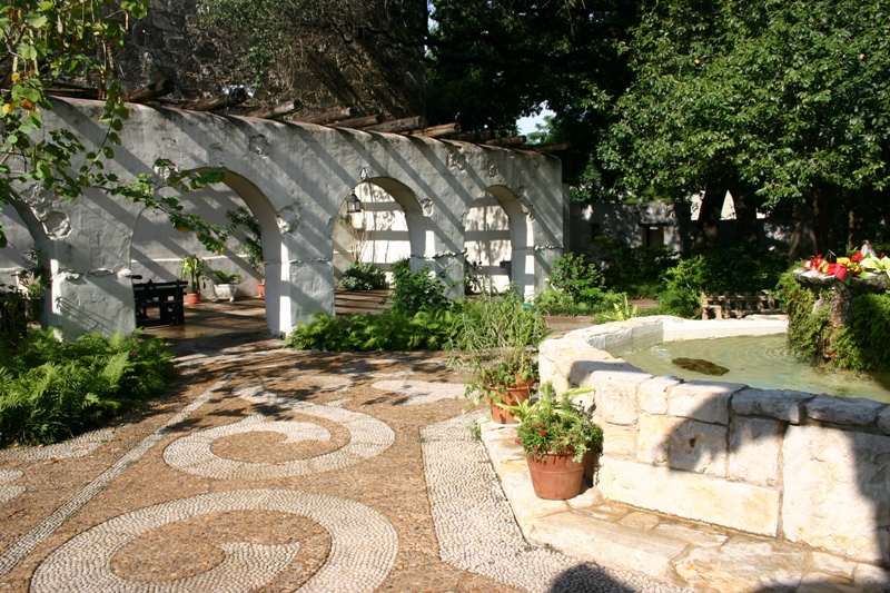 a garden is decorated with white flowers and stone walls