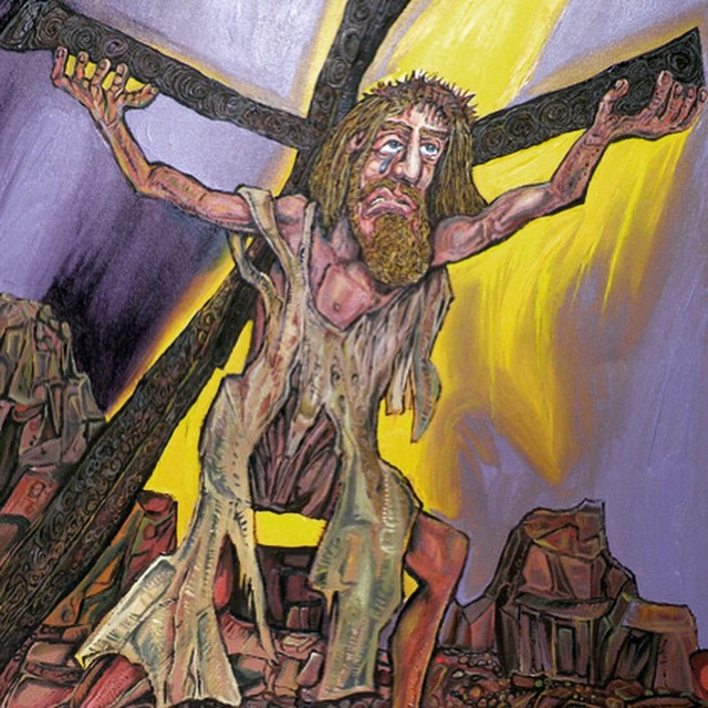 a man with large arms holding up the cross