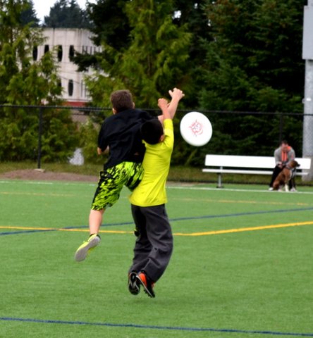 there are two people jumping in the air playing frisbee