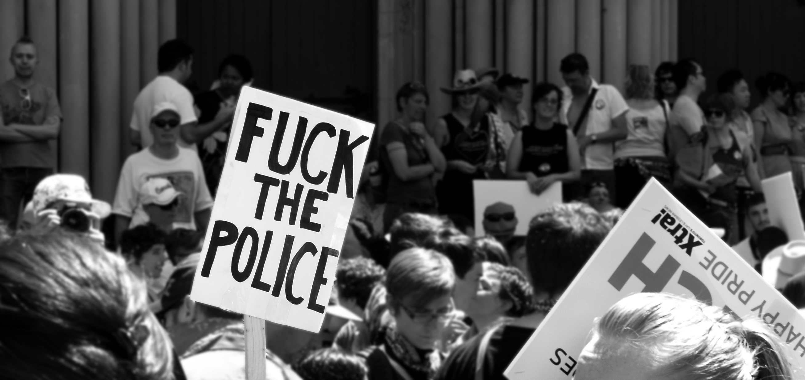 several people holding up protest signs on their sides