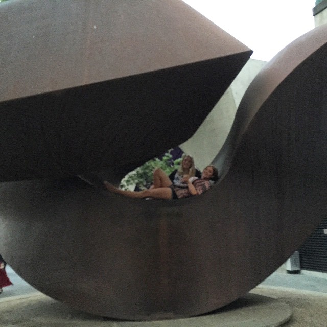 two women on a seat inside an artistic sculpture