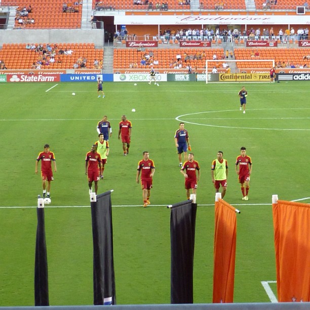 players walk around on the field during a soccer game