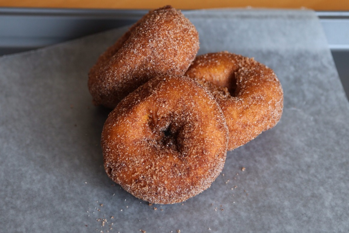 three sugar doughnuts are on a piece of paper