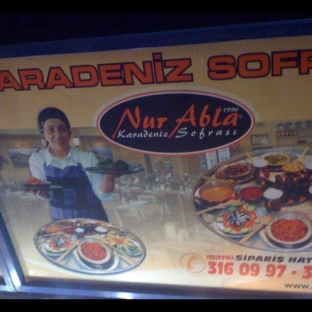 the sign for nurazila shows an image of a woman with dishes and food