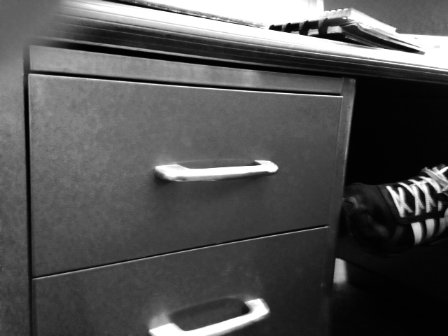 an image of an office drawer that has a pair of shoes on top of it