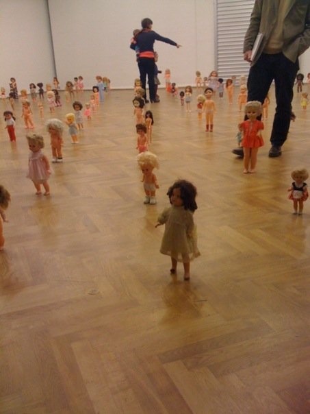 group of children standing on a wood floor in front of a man