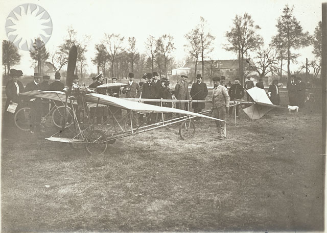 old black and white pograph of people standing around a plane
