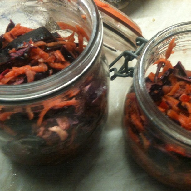 two glass jars with carrots and other fruit