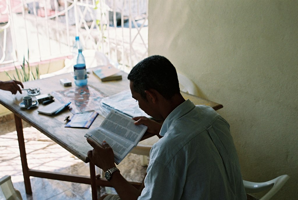 a person sits at a table while reading the book