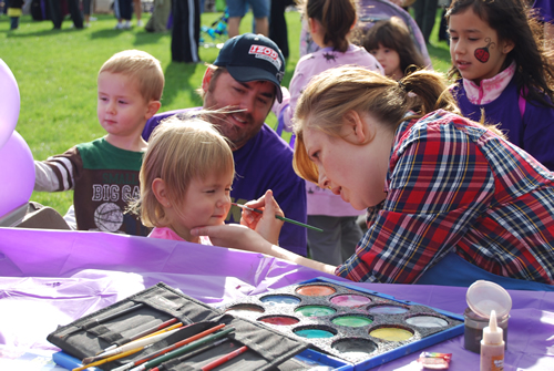 an artist doing her painting job at a park party