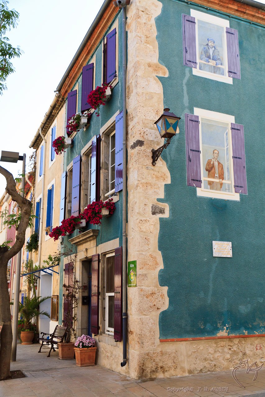 blue and green building with purple shutters in the windows