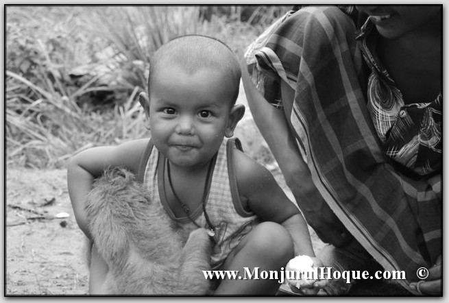 a black and white po of a little boy holding a baby goat