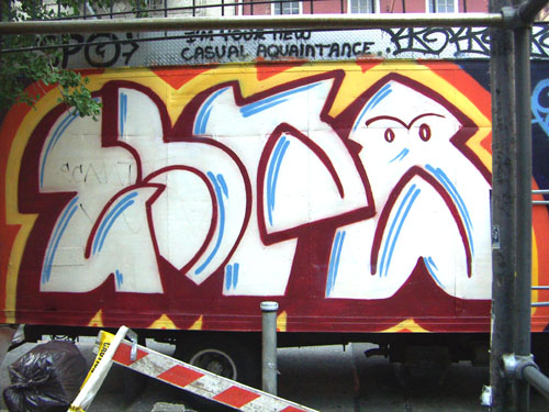a graffiti covered wall near a closed gate