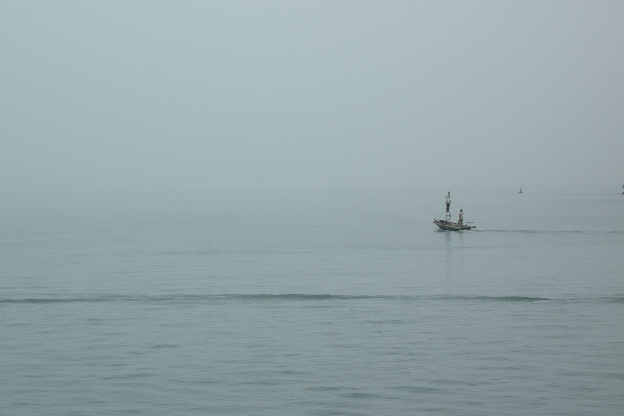 an old boat floating in the middle of the ocean