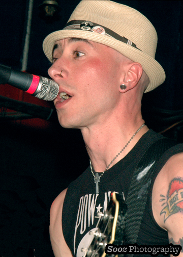 a man with a hat is singing into a microphone