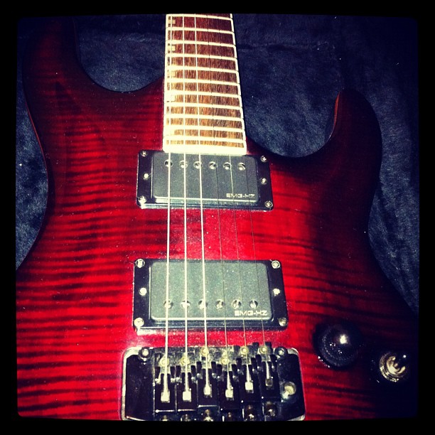 red guitar with strings and pickups laying down
