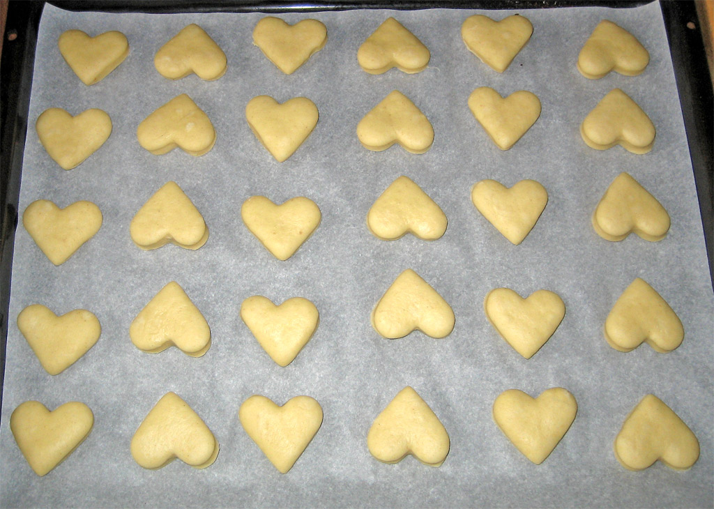 heart shaped cookies sitting on top of a cookie sheet