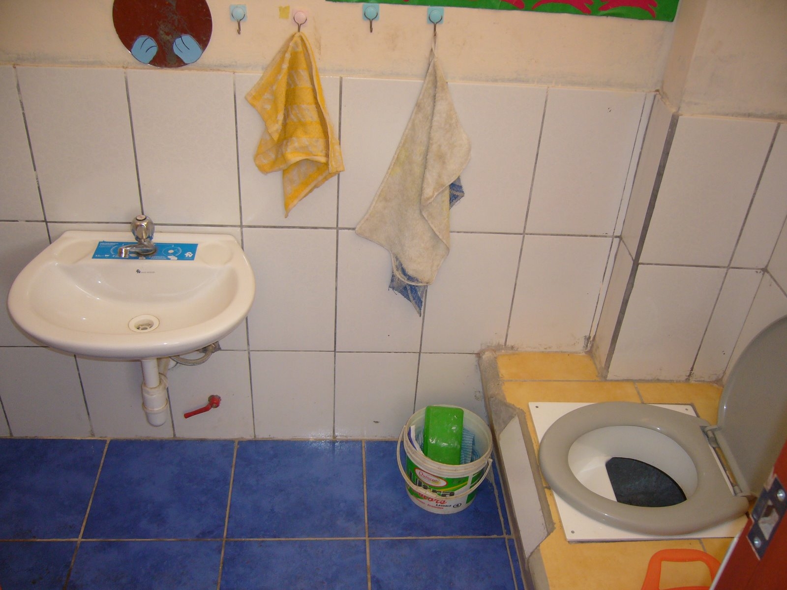 bathroom with sink and toilet with hanging towels