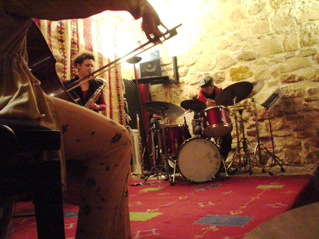 two musicians in a room with a red carpet and brick walls