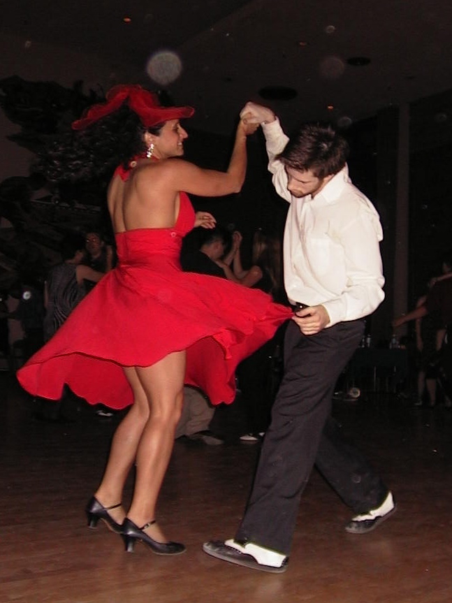 two people dance salsa at a ballroom