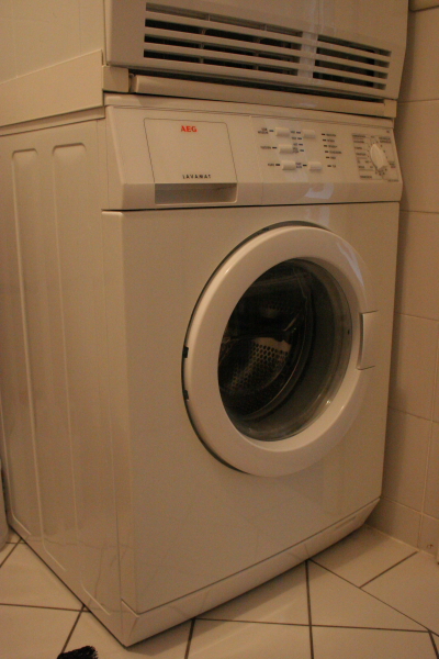a dryer sitting inside of a bathroom next to the tiled floor