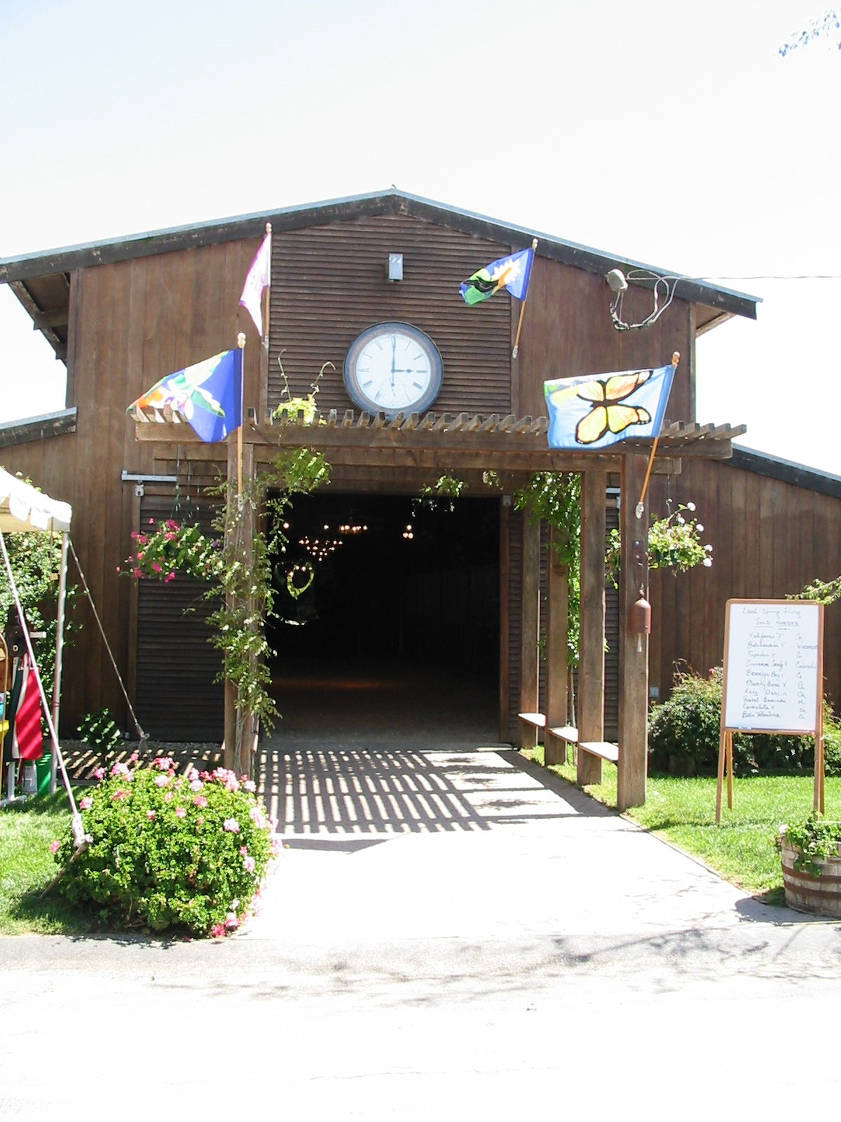 a garage in the shape of a barn with a clock