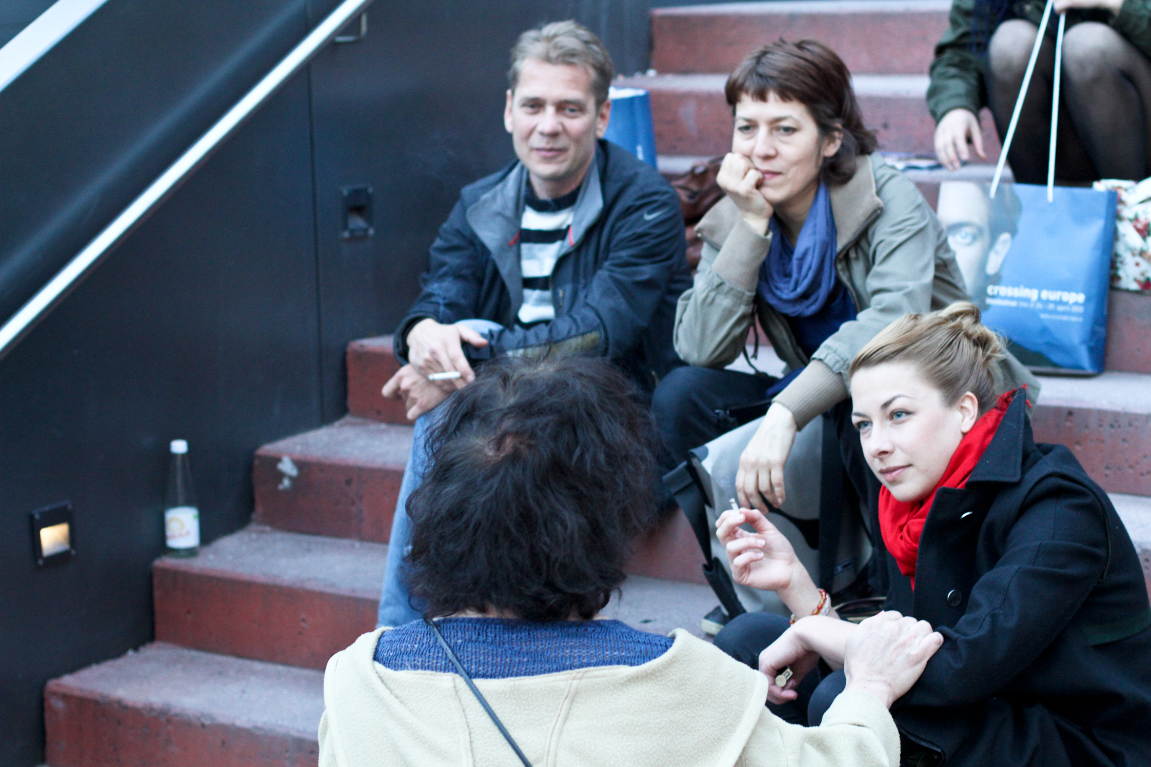 a group of people sitting down talking on stairs