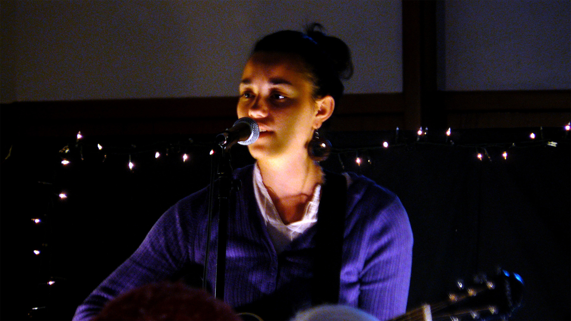 a person sitting on a chair playing the guitar