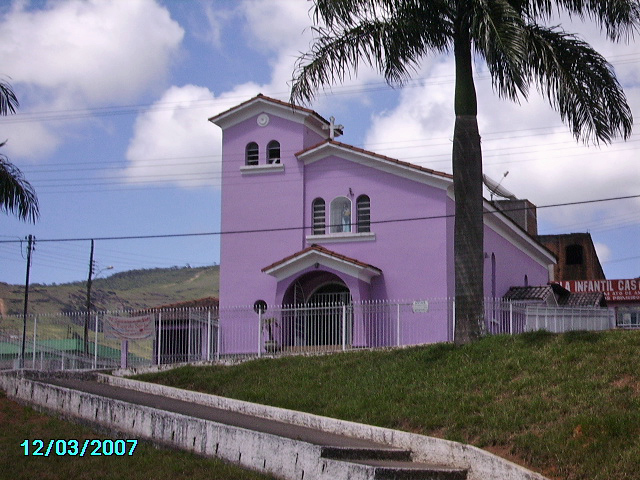 a church with a bright purple exterior and palm trees