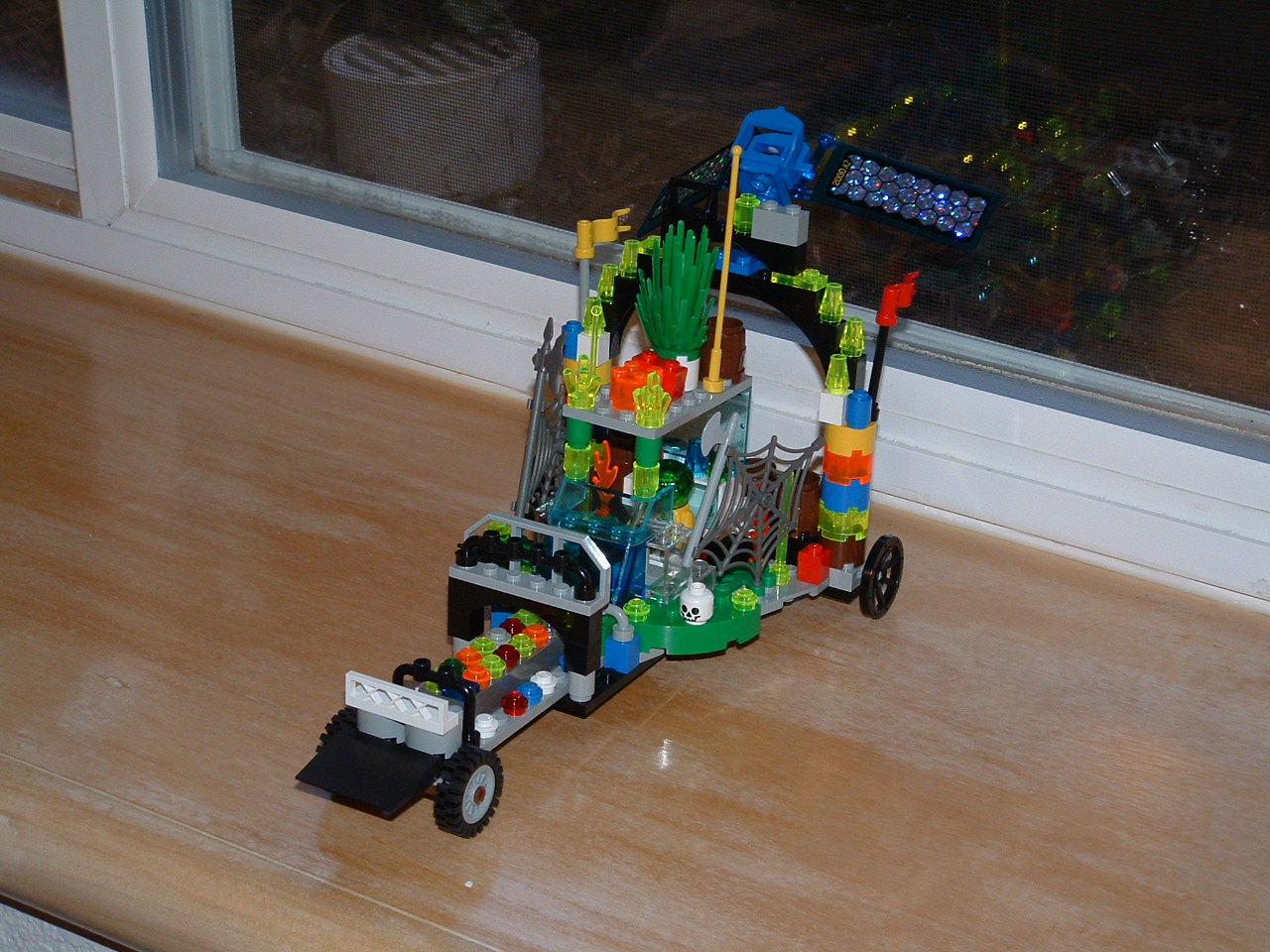 a small toy car made from lego blocks and toy dinosaurs