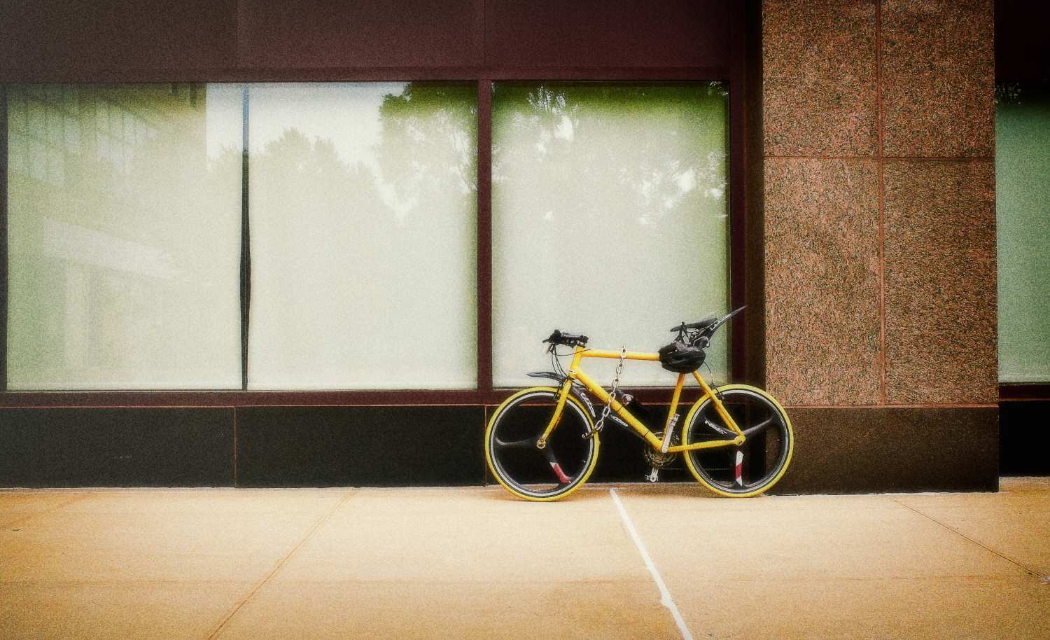 a yellow bike parked in front of a building