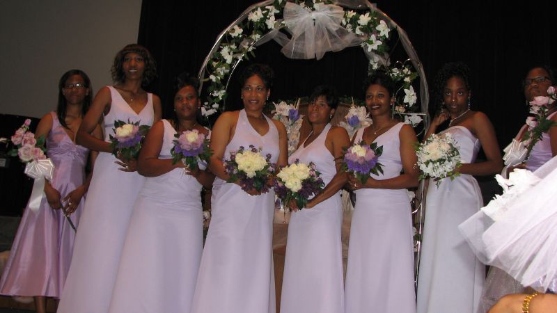 a group of bridesmaid standing with one holding flowers
