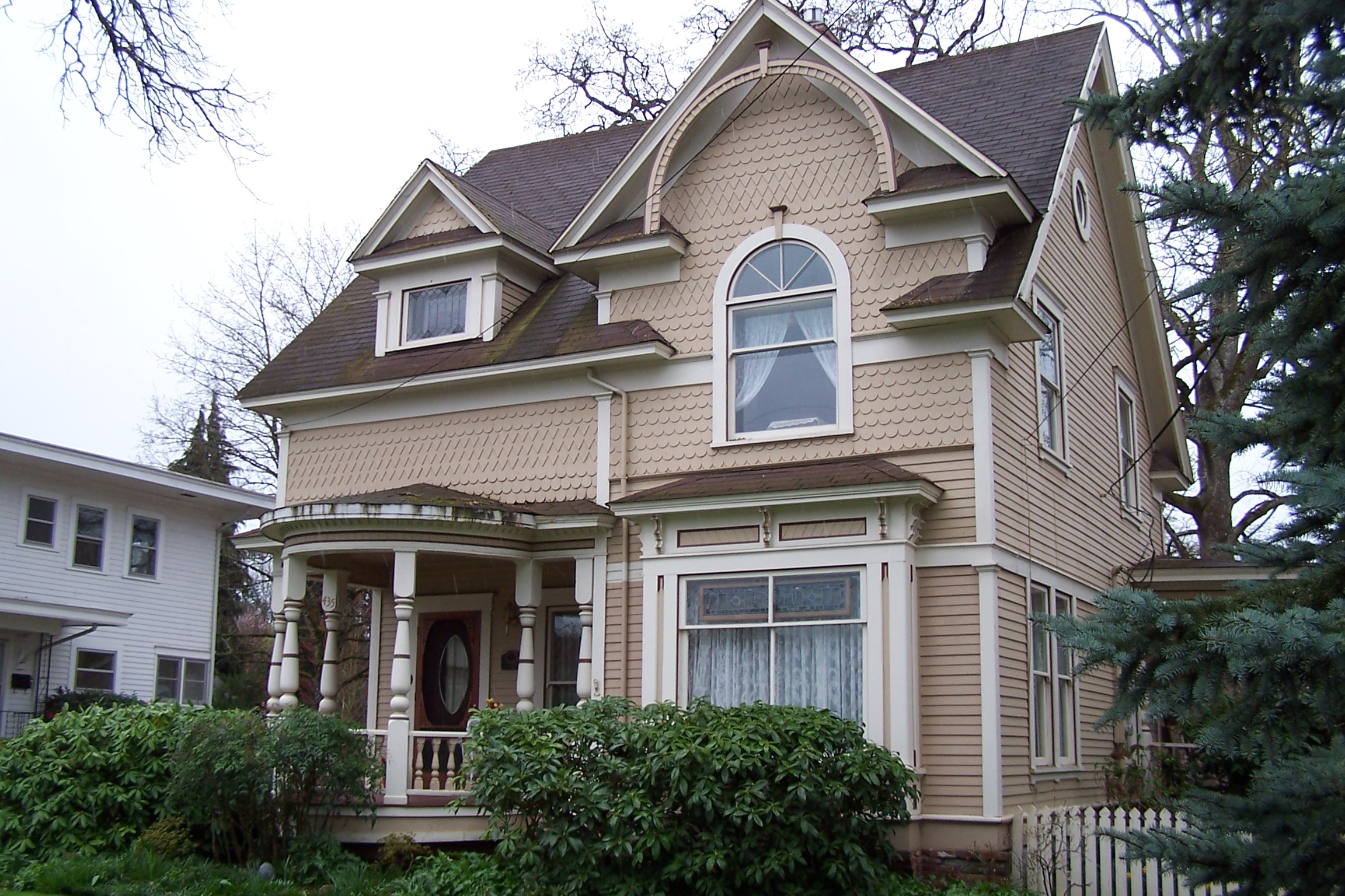 an old victorian home with a well painted and nice porch