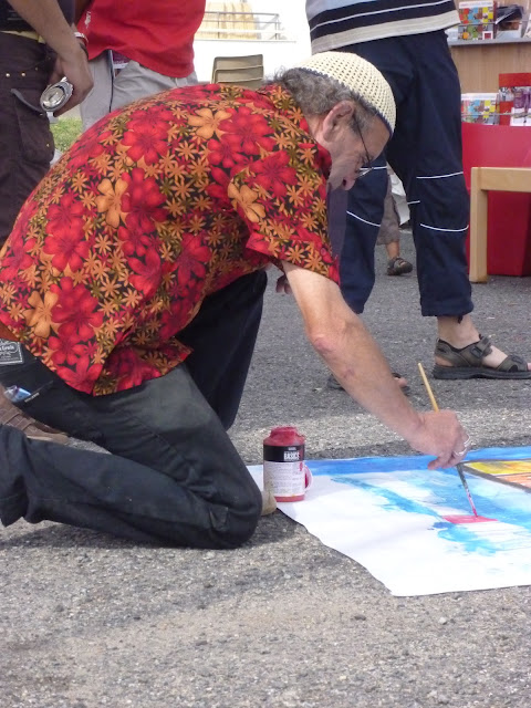 a man who is bending down with some paint