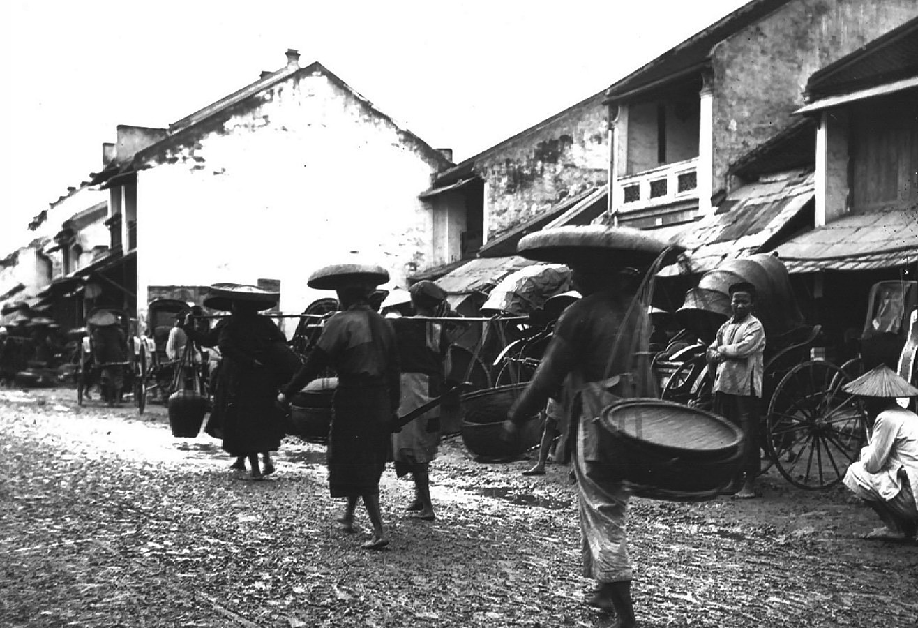 people in a village with lots of umbrellas and carts