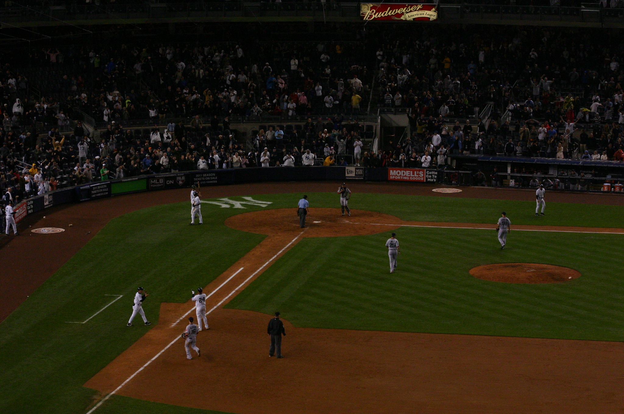 baseball players at home plate, with crowd in stands