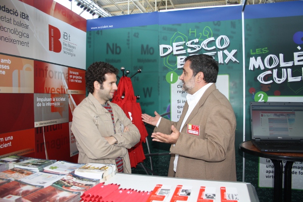 two men talking at a booth at a business event